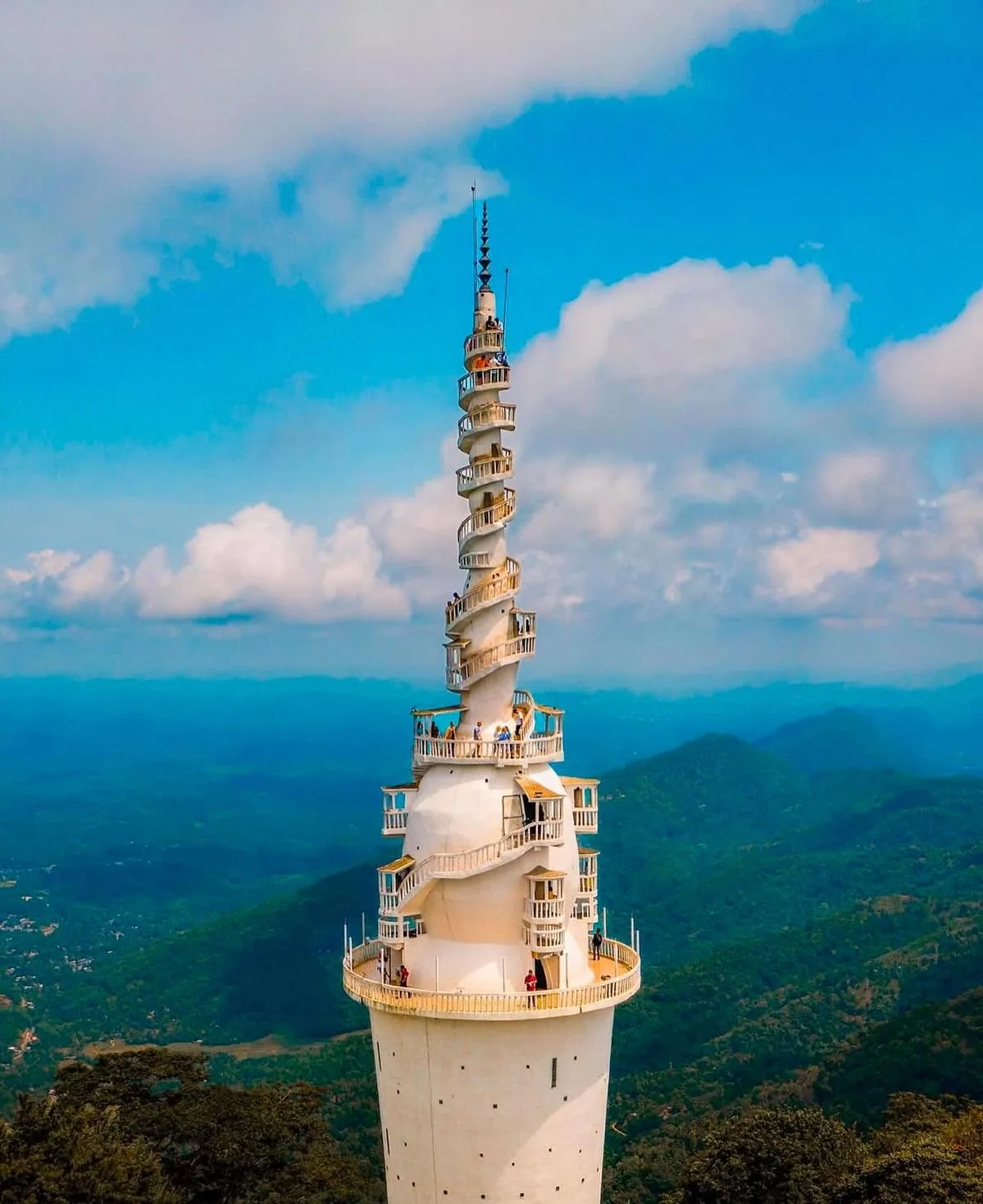 Ambuluwawa Tower stands against a clear blue sky and distant green hills.