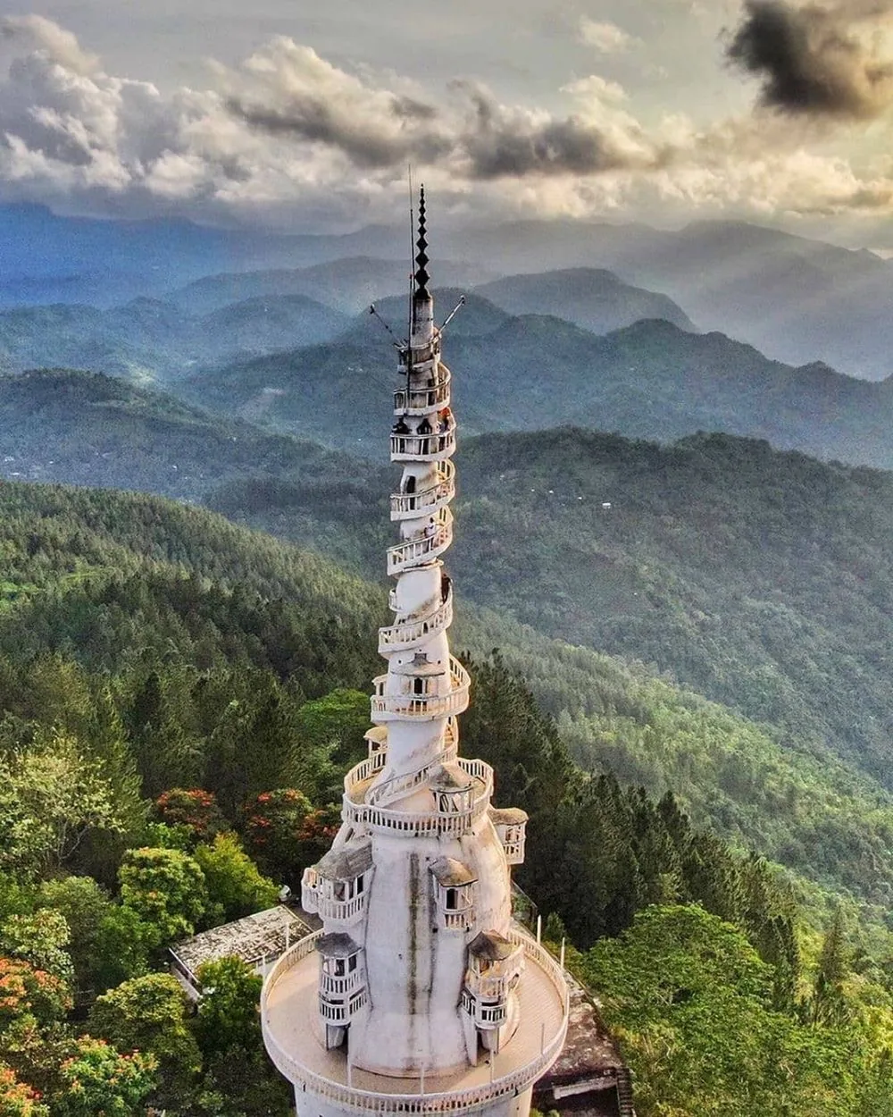 Ambuluwawa Tower rises above the green Gampola hills and drifting cloud.